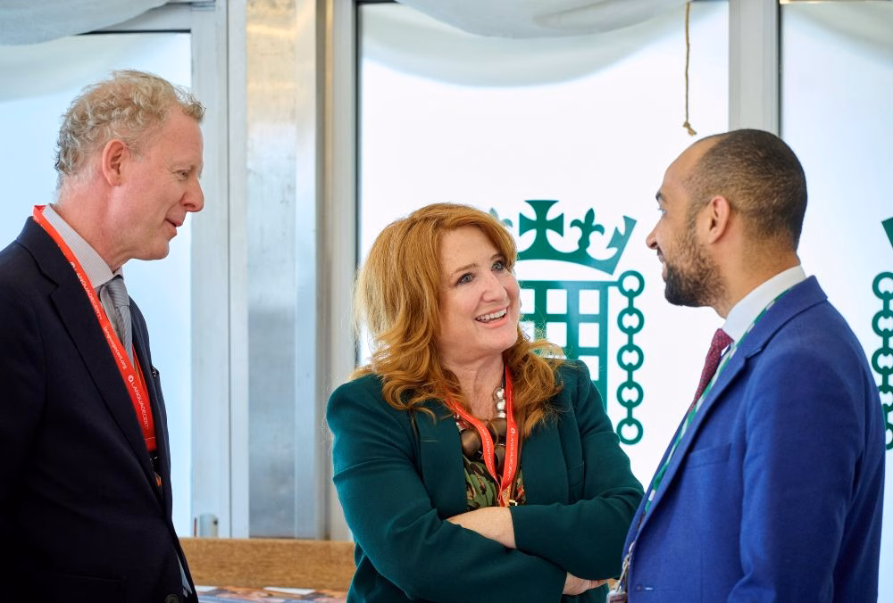 Two delegates taking to an MP at a reception in the Houses of Parliament